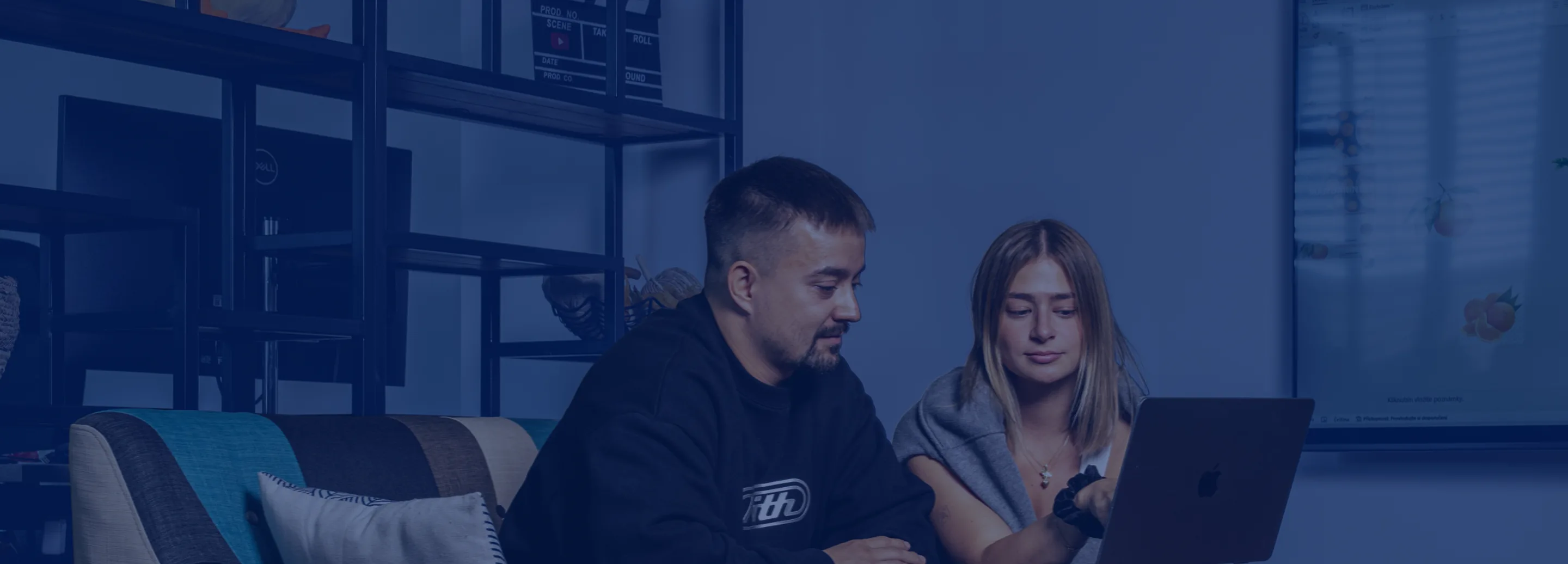 Kolegové ACOMWARE na pohovce společně procházejí prezentaci v notebooku
