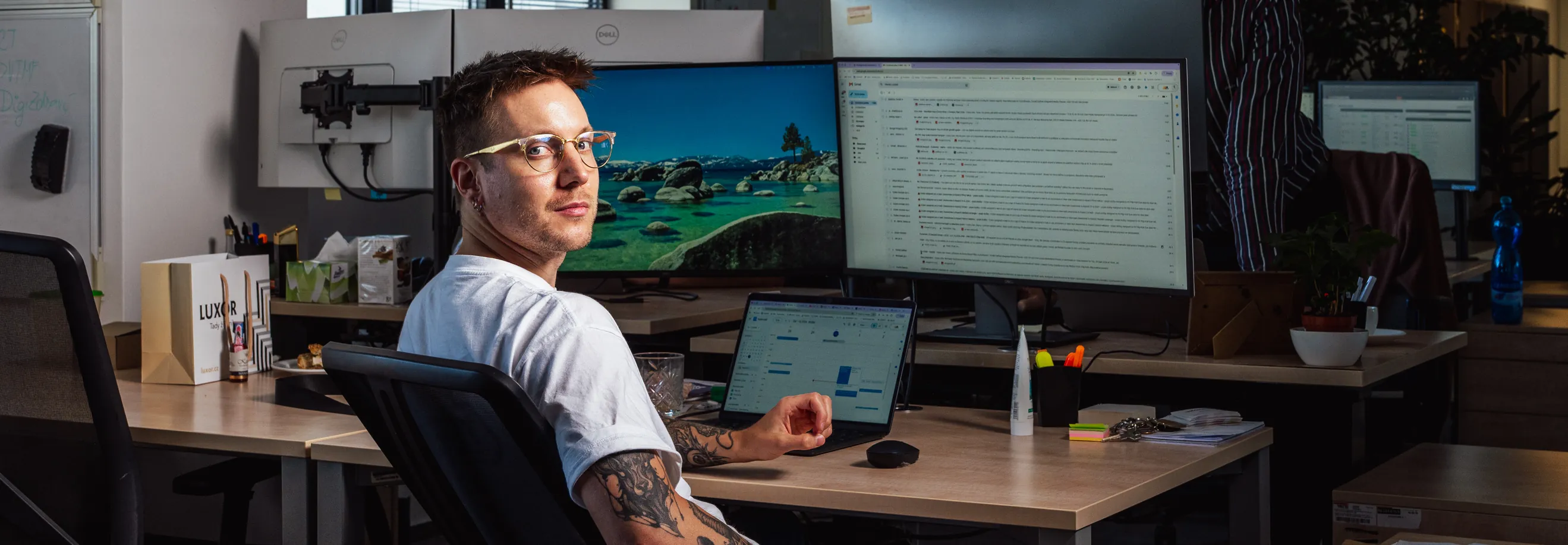 Kolega z ACOMWARE u pracovního stolu se dvěma monitory